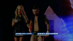 摔角手 Angelina Love 和 Davey Richards 一起在燈光閃耀的舞台上行走。