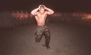 夜間軍事訓練中擦洗頭部的士兵，其他士兵列隊站立。