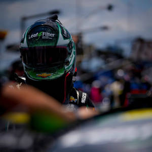 日落時分，NASCAR車手在賽車內戴著綠色和白色頭盔。 — 賽車 壁紙