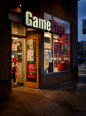 黃昏時分的GameStop商店外觀，明亮的窗戶和木門。 — iPad 第9代 壁紙