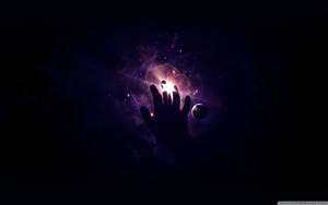 手伸入一個帶有星星和行星的發光宇宙星雲
