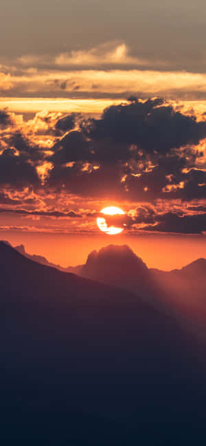 夕陽映照山巒，天空呈現橙色和紅色，伴隨深色雲層。
