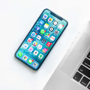 智能手機和筆記本電腦放在乾淨的白色桌子上進行數位工作。 — 手機鎖定螢幕 壁紙