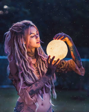 紋身女子在星空下懷抱發光月亮