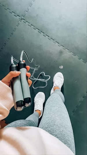 一個人手持跳繩在健身墊上準備鍛煉。 — 健身房 壁紙
