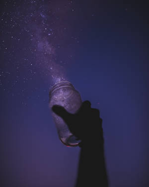 手拿著罐子，星星傾瀉到夜空