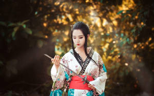 穿著和服的女性在金色陽光的森林中手持武士刀。