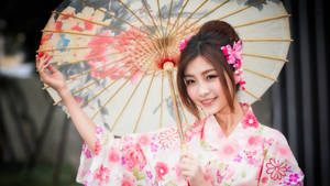 穿著粉紅色花卉和服的女性手持花卉陽傘