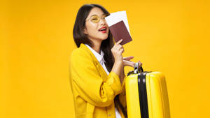 微笑的女性拿著護照和行李箱準備旅行。 — 黃色 壁紙
