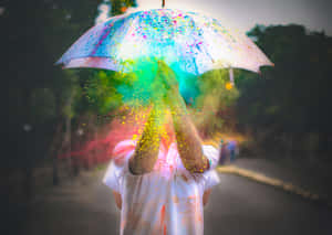 一個人在公園的雨傘下拋出彩色粉末。