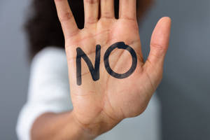 手掌上寫著「NO」的手，用以表示拒絕或停止。