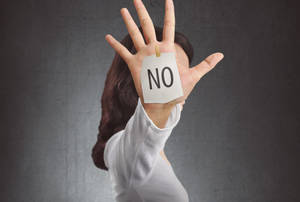 舉起手，臉上貼有「NO」紙條的人。