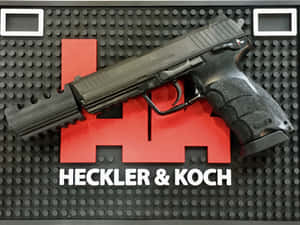 黑色Heckler & Koch手槍放在帶有紅色標誌的品牌展示墊上。