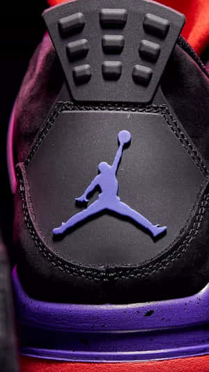 黑色運動鞋上紫色 Jumpman 標誌的特寫，帶有紅色點綴。