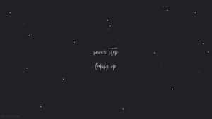 星空夜空，以白色草書寫著勵志名言 never stop looking up。