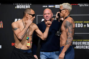 兩名肌肉發達的紋身拳手在稱重時與裁判鎖拳。