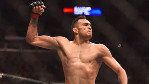 勝利的MMA戰士在八角籠中舉起拳頭。