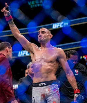 UFC拳手在八角籠內舉拳慶祝勝利。