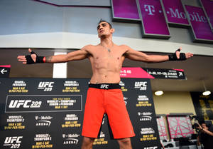 UFC拳手在稱重活動中站在體重磅上張開雙臂