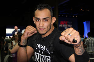 MMA 拳手穿黑色襯衫在 UFC 賽事中舉拳擺姿勢。