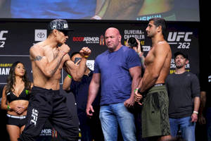 兩名男性MMA拳手在UFC稱重儀式上對峙，中間站著一名裁判。