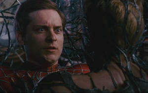 蜘蛛俠面對毒液，黑色觸手在緊張時刻纏繞著他們。