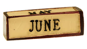 一個風化的木塊，上面刻有黑色字母 JUNE。