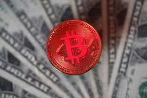 紅色比特幣硬幣放在展開的美鈔上。 — 比特幣 壁紙