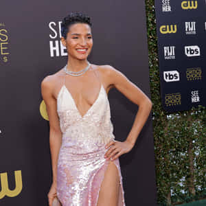 身穿閃亮粉紅色禮服的女性在 Critics Choice Awards 紅地毯活動中擺姿勢。
