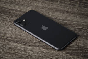 黑色iPhone放在灰色木桌上