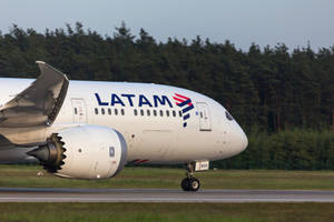 LATAM飛機在跑道上，背景為森林，日間