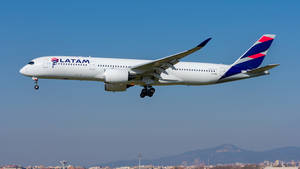 LATAM飛機以山脈和城市為背景降落