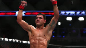 MMA鬥士在八角籠中舉起拳頭慶祝勝利。