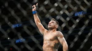 MMA拳手在八角籠內舉起拳頭慶祝勝利。