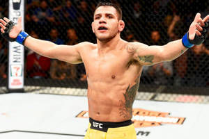 MMA拳手在UFC八角籠內高舉雙臂慶祝勝利。