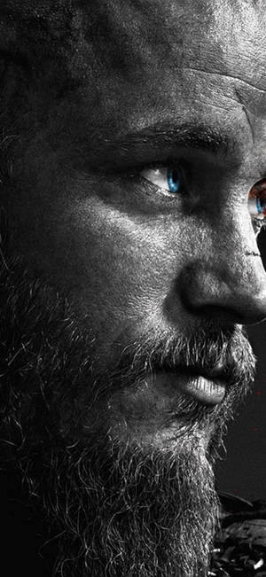 鬍鬚男嘅近距離肖像，有強烈嘅藍眼睛同戲劇性燈光。