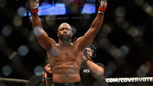 MMA選手在八角籠中舉臂慶祝勝利。