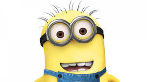 一個戴著護目鏡和牛仔布工人褲的黃色動畫Minion，露出燦爛的笑容。