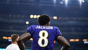 美式足球員Jackson 8號夜晚站在體育場。