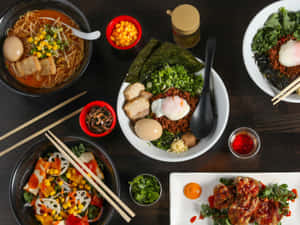 擺盤的亞洲菜餚，包括拉麵、韓式拌飯和辣味雞肉，附有裝飾和醬汁。 — 美食 壁紙