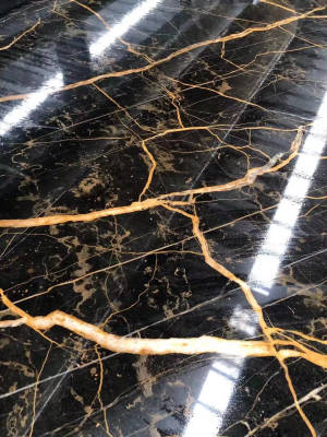 帶有金色紋理的黑色大理石地板反射光線。 — 雲石動態 壁紙