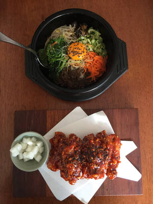 韓國石鍋拌飯和辣雞肉配蘿蔔在木桌上 — 清新 GIF 壁紙