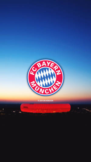 黃昏時分，FC Bayern München 標誌位於燈光球場上方。