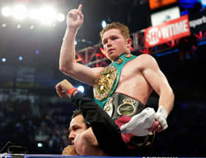 拳擊手Canelo Alvarez在擂台上帶著冠軍腰帶慶祝勝利。
