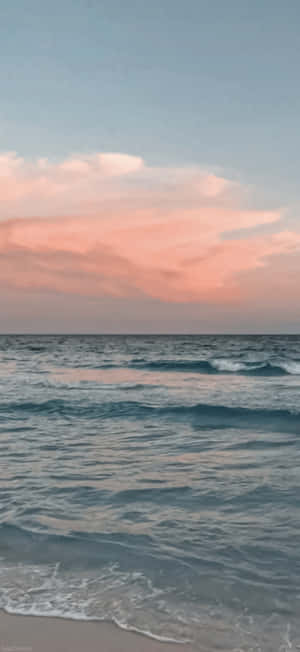 日落時分的海浪，粉紅雲彩倒映在水面上。