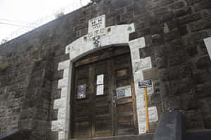 HM Prison 1902入口，配有木門和上方鐵絲網。