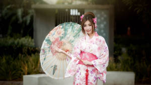 身穿粉色花卉和服的女性在花園中手持裝飾傘 — 日本 壁紙