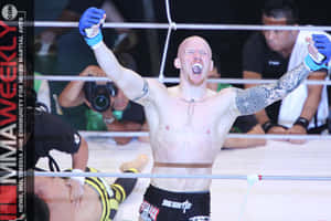 光頭MMA拳手在擂台上高舉雙臂慶祝勝利。 — 夢境 GIF 壁紙