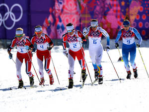五名身穿奧運制服的女滑雪選手在雪道上。