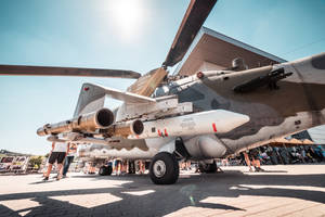 軍用直升機在戶外航空展上展示導彈，陽光燦爛。 — 直升機 壁紙